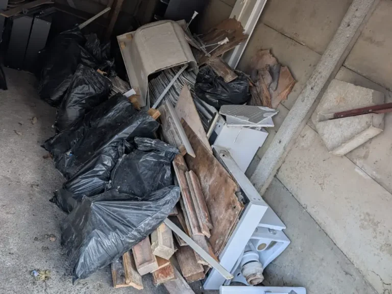 Old basin, toilet, bath panels, flooring and bags from a bathroom strip-out in Tottenham, ready for collection