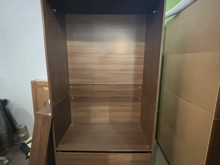 Dark wood shelf unit taken apart in a London Fields studio, ready for removal