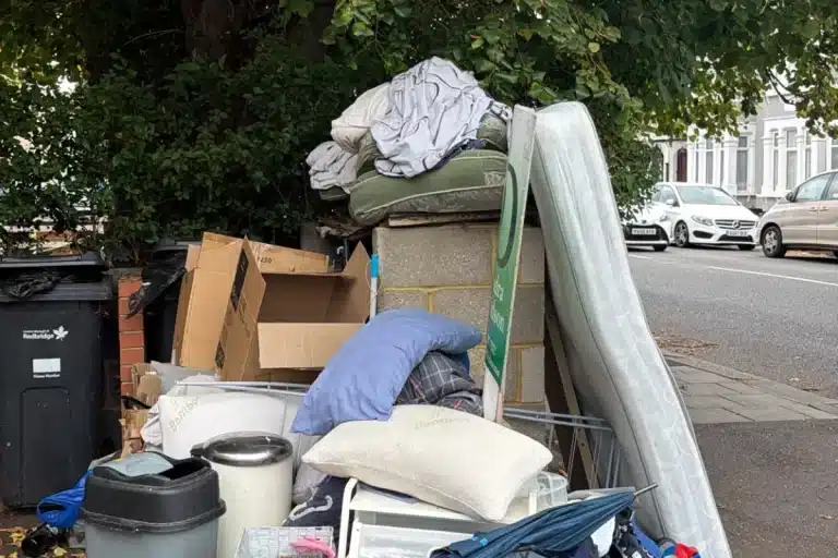 Household rubbish, boxes, bins and a mattress waiting for collection